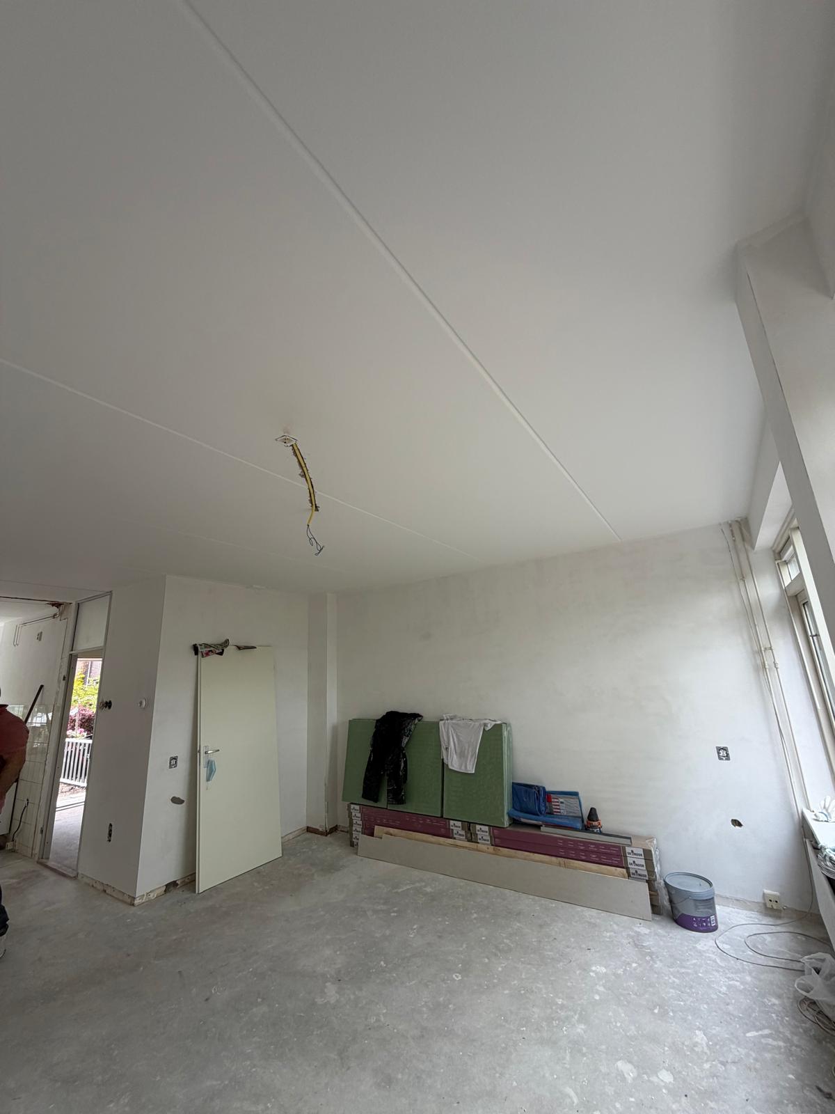 Woonkamer met strak gestuukt plafond — stucadoor Noord-Holland