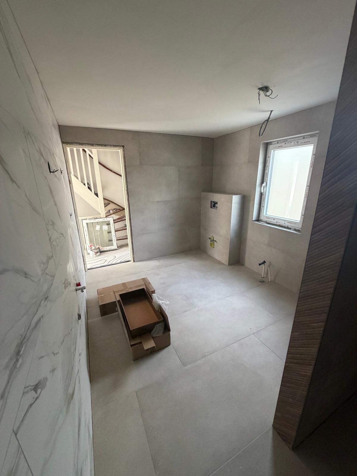 Badkamer met marmerlook wand en grote betonlook vloertegels — badkamerrenovatie Noord-Holland