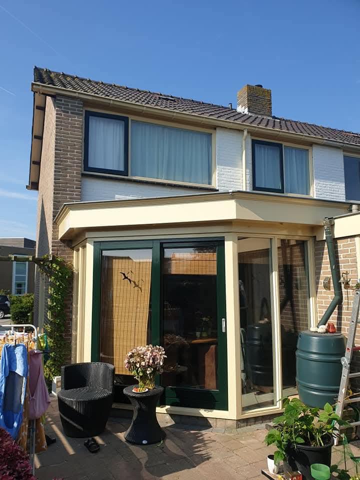 Buitenschilderwerk woning met crème kozijnen en groene deur