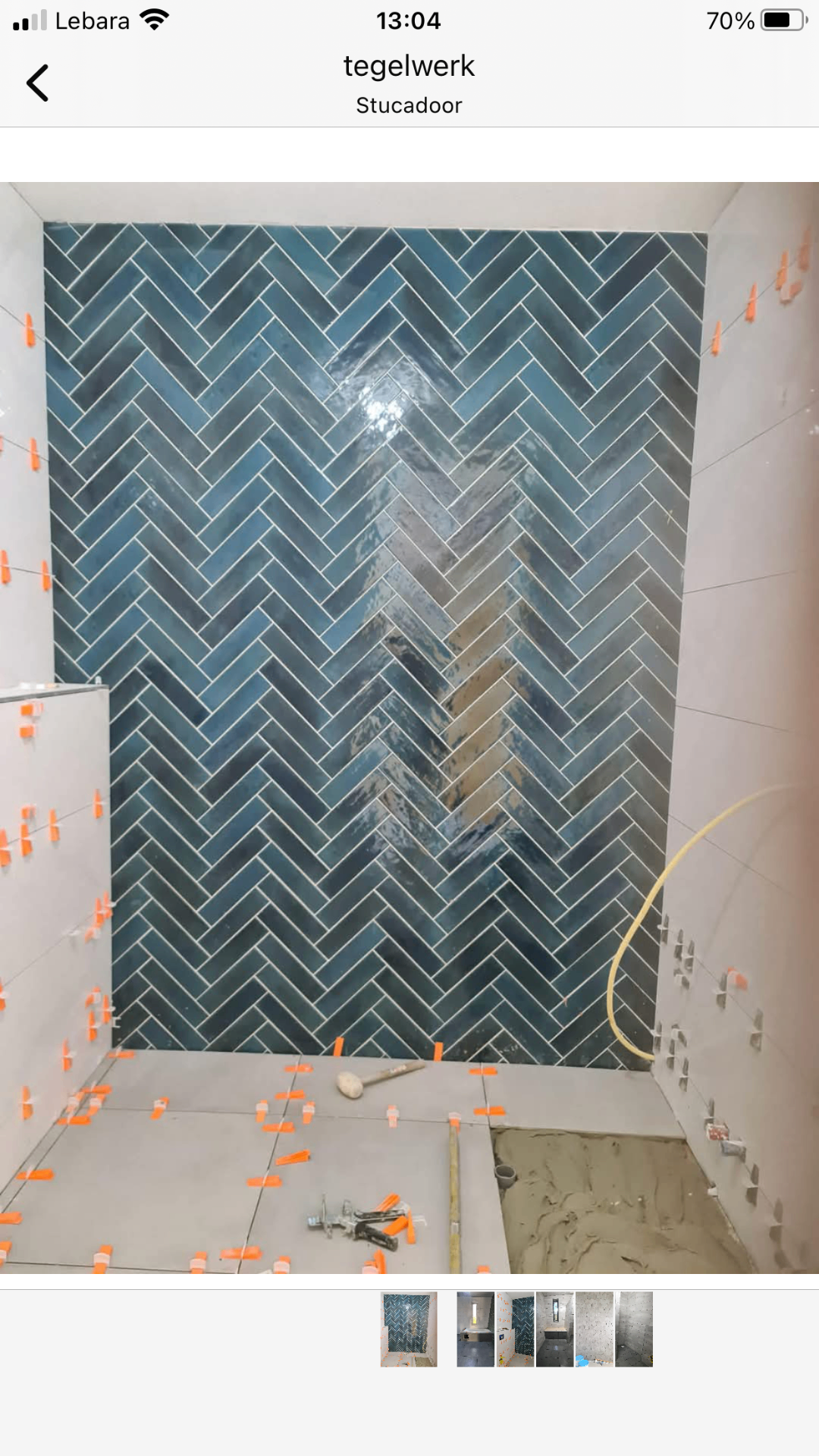 Badkamer met petrolblauwe glanzende visgraat wandtegels — tegelzetter Noord-Holland
