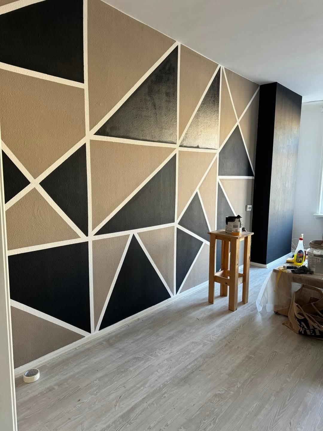 Geometrische driehoek accentmuur in zwart en beige — schilderwerk Noord-Holland