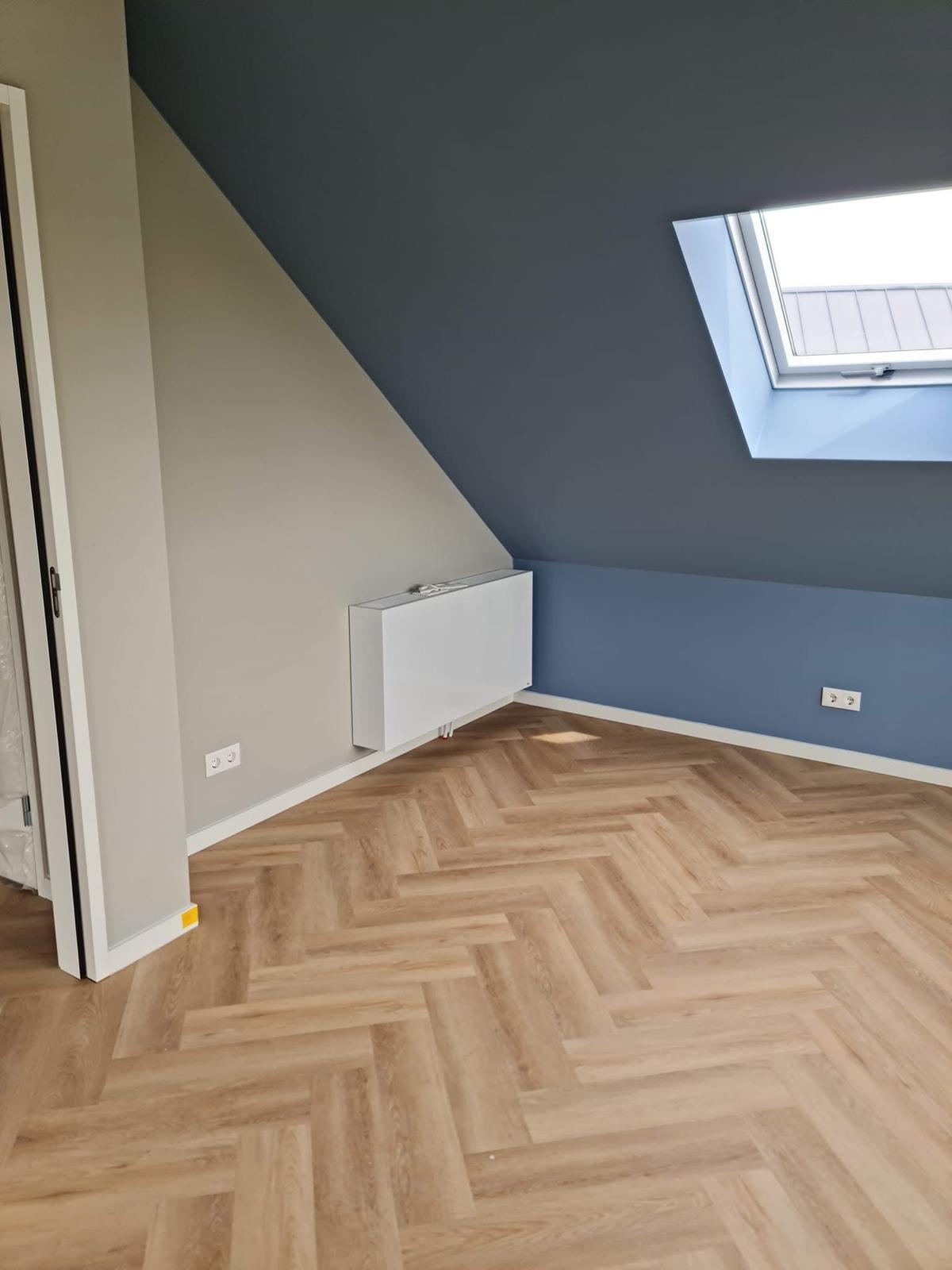Slaapkamer geschilderd in blauw en grijs met visgraatvloer