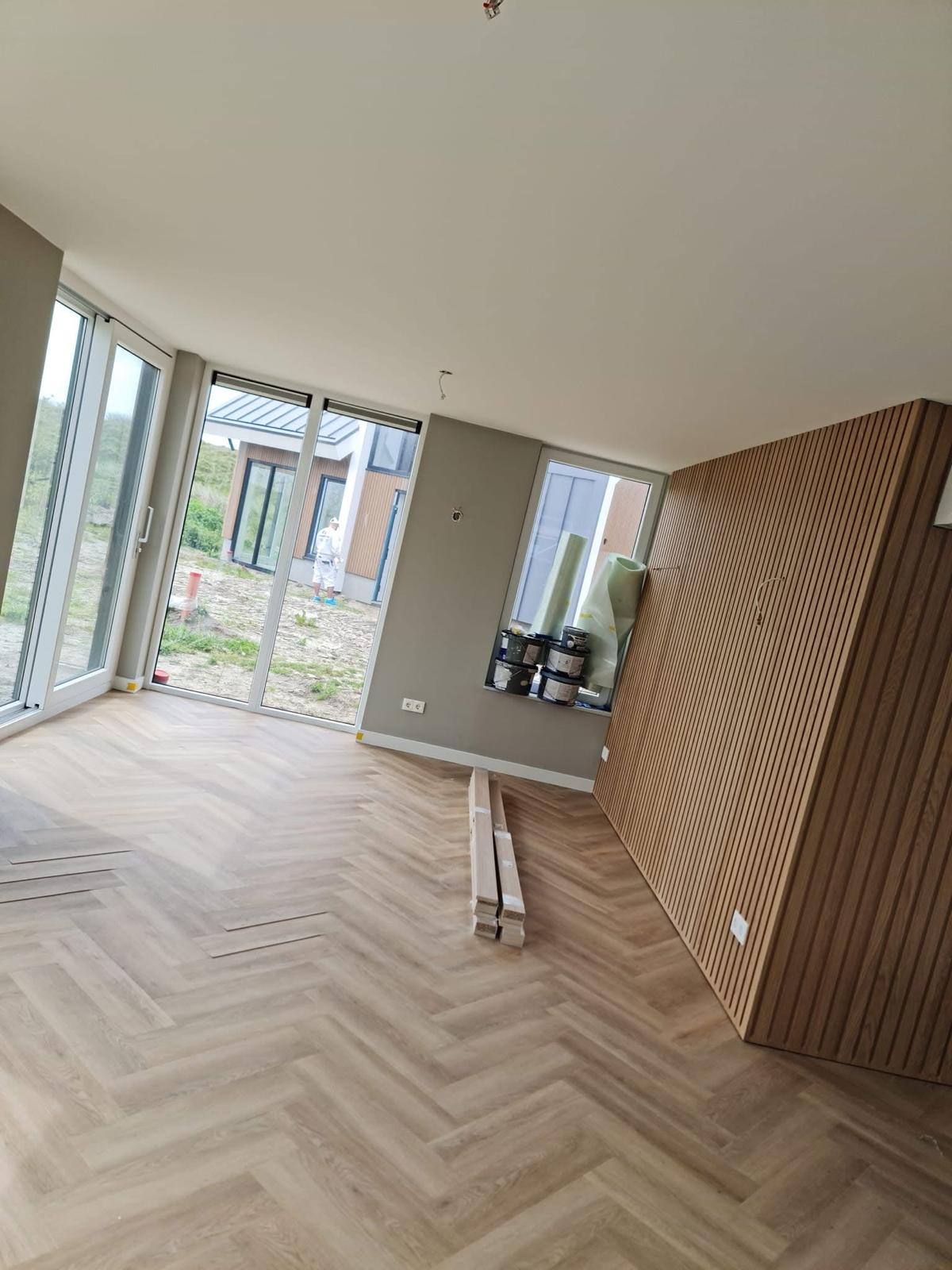 Woonkamer met stucwerk en akoestisch houten wandpaneel