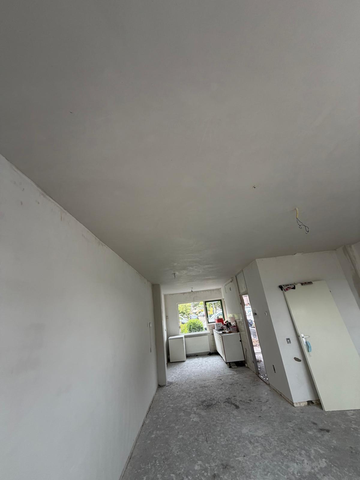 Woonkamer en keuken volledig sausklaar gestuukt tijdens renovatie — stucadoor Noord-Holland